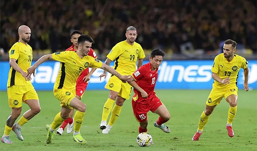 Pemain Malaysia (kuning) saat menghadai Vietnam